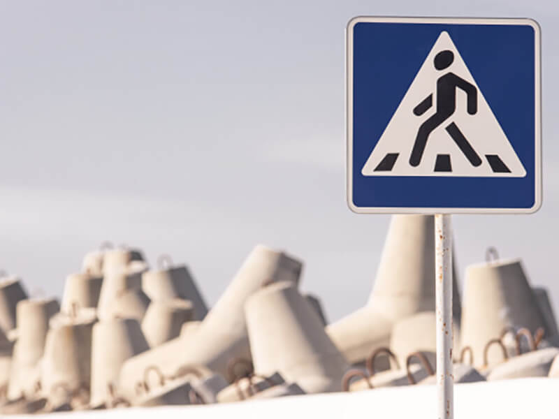 Фото пляжа с волнорезами и знаком пешеходного движения